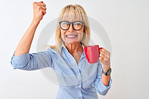 Middle age businesswoman wearing glasses drinking coffee over isolated white background annoyed and frustrated shouting with