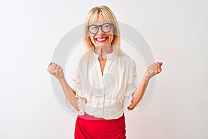Middle age businesswoman wearing shirt and glasses standing over isolated white background very happy and excited doing winner