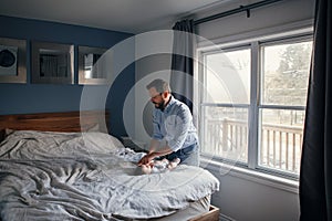 Middle age Caucasian father changing diaper clothes for newborn baby daughter son. Man parent taking care of child at home.