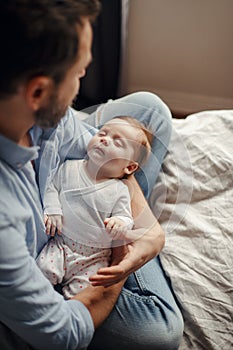 Middle age Caucasian father with sleeping newborn baby girl. Parent holding rocking a child daughter son in hands. Authentic