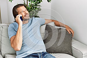 Middle age caucasian man smiling confident talking on the smartphone at home