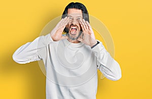 Middle age caucasian man wearing casual clothes shouting angry out loud with hands over mouth