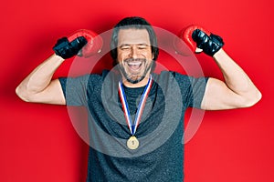 Middle age caucasian man wearing first place medal on boxing competition smiling and laughing hard out loud because funny crazy