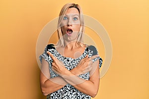 Middle age caucasian woman pointing up with fingers to different directions afraid and shocked with surprise and amazed