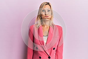 Middle age caucasian woman wearing business jacket puffing cheeks with funny face