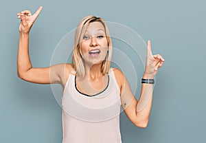 Middle age caucasian woman wearing casual clothes smiling amazed and surprised and pointing up with fingers and raised arms