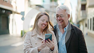 Middle age couple couple smiling confident making selfie by the smartphone at street
