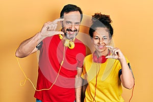 Middle age couple of hispanic woman and man wearing sportswear and arm band smiling and confident gesturing with hand doing small