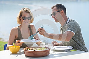 Middle-age couple on holidays eating outside