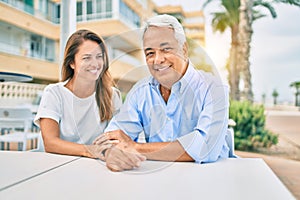 Middle age couple in love sitting at the terrace of coffee shop happy and cheerful together