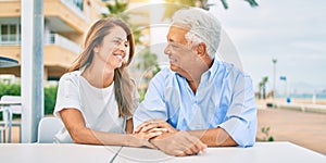 Middle age couple in love sitting at the terrace of coffee shop happy and cheerful together