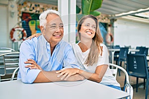 Middle age couple in love sitting at the terrace of coffee shop happy and cheerful together