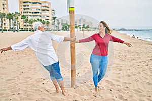 Middle age couple in love walking having fun ath the beach happy and cheerful together