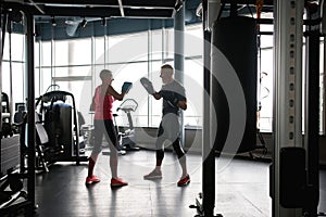 Middle age couple smiling, training boxing at gym