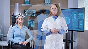 Middle age doctor in moder facility for brain research making hand gesture