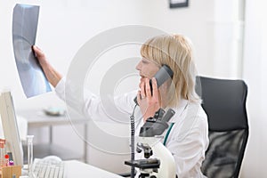 Middle age doctor woman speaking phone