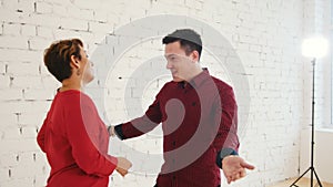 Middle age female and young man is dancing kizomba in studio, close up