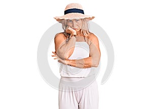 Middle age fit blonde woman wearing summer hat thinking looking tired and bored with depression problems with crossed arms