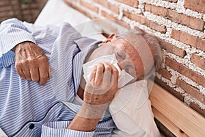 Middle age grey-haired man illness lying on bed at bedroom