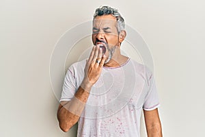 Middle age grey-haired man wearing casual clothes bored yawning tired covering mouth with hand