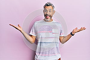 Middle age grey-haired man wearing casual clothes celebrating victory with happy smile and winner expression with raised hands