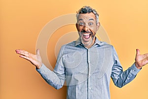 Middle age grey-haired man wearing casual clothes celebrating victory with happy smile and winner expression with raised hands