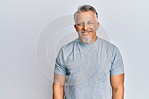 Middle age grey-haired man wearing casual clothes with a happy and cool smile on face