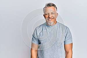 Middle age grey-haired man wearing casual clothes with a happy and cool smile on face photo