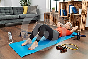 Middle age grey-haired woman training abs exercise at home