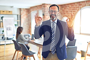 Middle age handsome businessman wearing glasses   standing at the office relax and smiling with eyes closed doing meditation