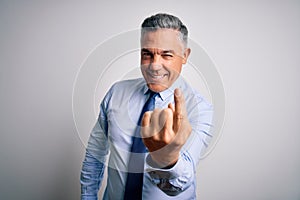 Middle age handsome grey-haired business man wearing elegant shirt and tie Beckoning come here gesture with hand inviting