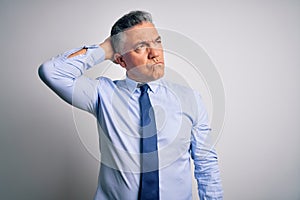 Middle age handsome grey-haired business man wearing elegant shirt and tie confuse and wondering about question