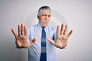 Middle age handsome grey-haired business man wearing elegant shirt and tie Moving away hands palms showing refusal and denial with