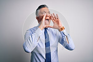 Middle age handsome grey-haired business man wearing elegant shirt and tie Shouting angry out loud with hands over mouth
