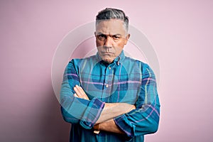 Middle age handsome grey-haired man wearing casual shirt over isolated pink background skeptic and nervous, disapproving