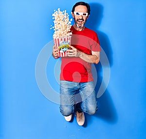 Middle age handsome hispanic man watching movie using 3d glasses similing happy