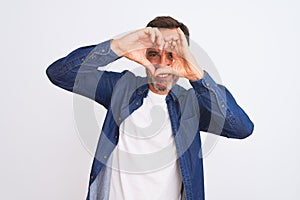Middle age handsome man wearing blue denim shirt standing over isolated white background Doing heart shape with hand and fingers
