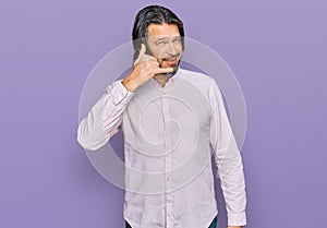 Middle age handsome man wearing business shirt smiling doing phone gesture with hand and fingers like talking on the telephone