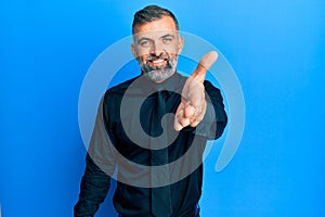 Middle age handsome man wearing business shirt and tie smiling friendly offering handshake as greeting and welcoming