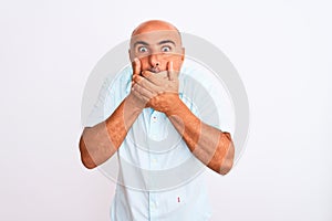 Middle age handsome man wearing casual shirt standing over isolated white background shocked covering mouth with hands for mistake