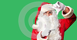 Middle age handsome man wearing Santa Claus costume and beard standing smiling making frame with hands and fingers with happy face