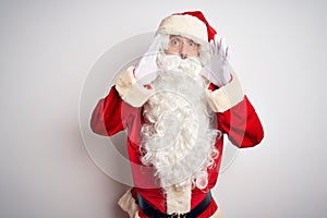 Middle age handsome man wearing Santa costume standing over isolated white background Shouting angry out loud with hands over