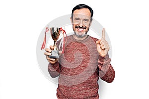 Middle age handsome man winning trophy for victory over isolated white background smiling with an idea or question pointing finger