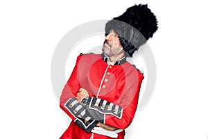 Middle age handsome wales guard man wearing traditional uniform over white background looking to the side with arms crossed