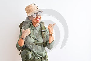 Middle age hiker woman wearing backpack canteen hat glasses over isolated white background smiling with happy face looking and