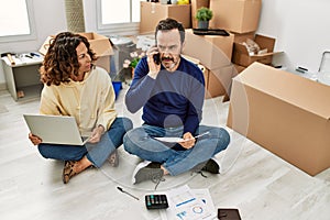 Middle age hispanic couple controlling family economy using laptop