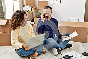 Middle age hispanic couple controlling family economy using laptop