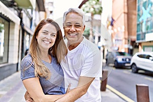 Middle age hispanic couple of husband and wife together on a sunny day outdoors