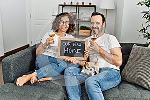 Middle age hispanic couple smiling happy toasting with champagne