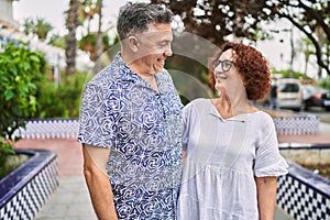 Middle age hispanic couple together outdoors on summer day